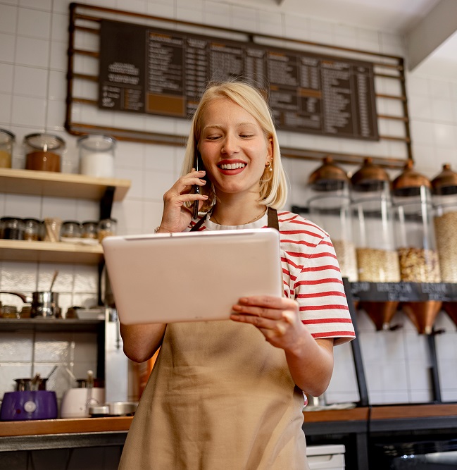 Male and female employees in a bakery holding a tablet and talking